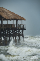 More waves sweep under the pier.