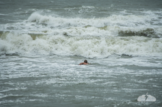 A swimmer braves the gnarly surf.