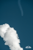 The SpaceX rocket far downrange appears to approach the contrail it left behind.