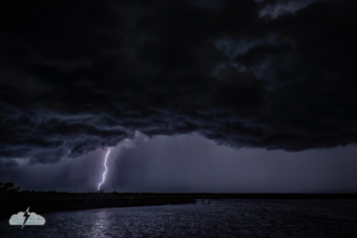 A bolt fires under the ominous incoming storm.