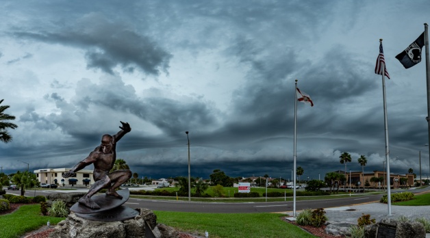 A panorama of the shelf cloud with the Kelly Slater statue in the foreground.